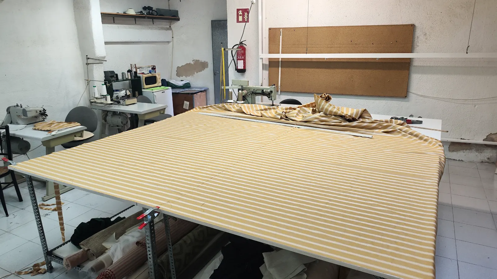 Tejido extendido en la mesa de corte del taller